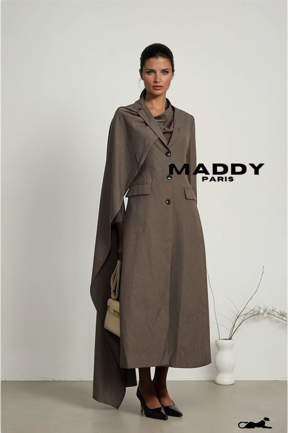 Woman wearing a long brown coat with 'MADDY PARIS' branding on a white background