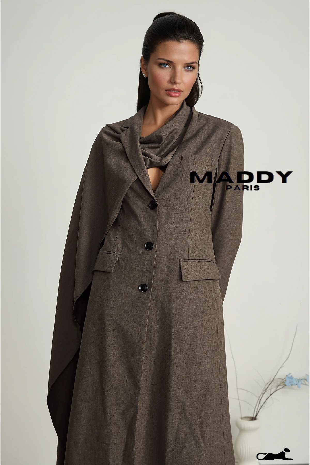 Woman wearing a brown coat with 'Maddy Paris' branding on a plain background