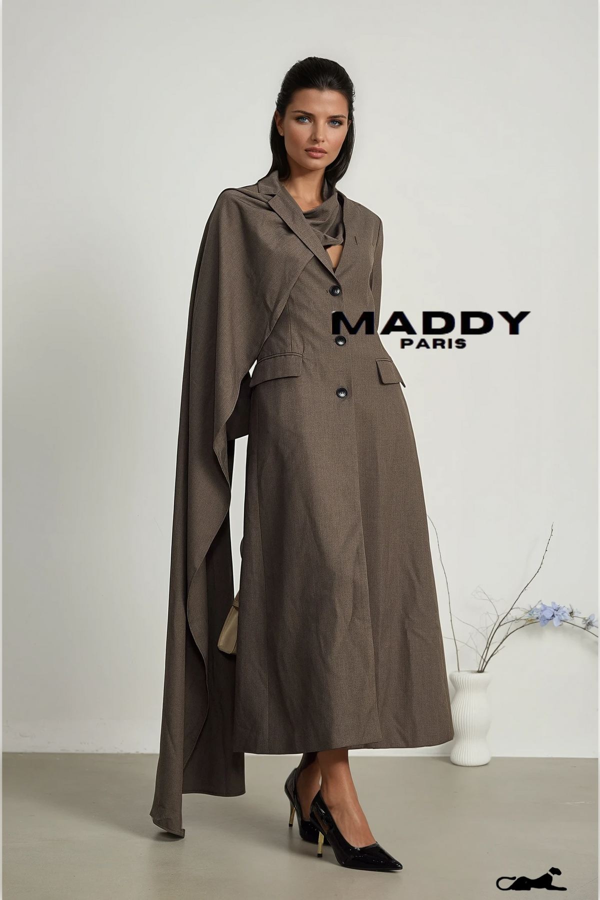 Woman wearing a long brown coat with 'MADDY PARIS' branding on a white background