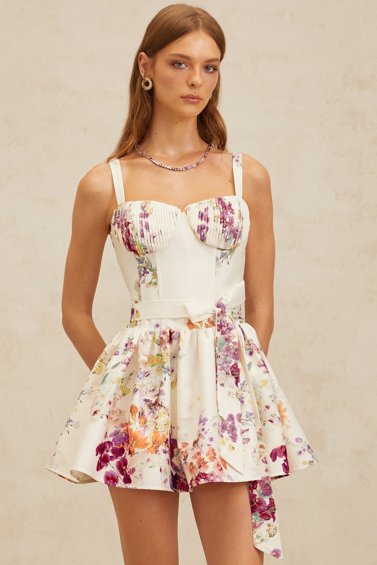 Woman wearing a floral dress against a beige background